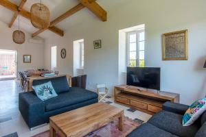 a living room with a couch and a tv at Mas Picholine - Maison pour 10 avec piscine in Saint-Jean-de-Maruéjols-et-Avéjan