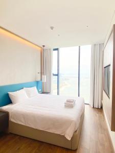 - une chambre avec un grand lit et une grande fenêtre dans l'établissement A La Carte Hạ Long Bay View 2, à Hạ Long