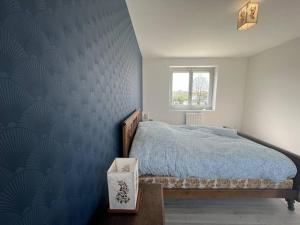 una camera con letto e parete blu di Le gite du Presbytère du Talbert a Pleubian