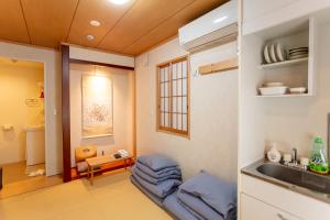 una cucina con lavandino e un divano in una camera di 和縁WAEN SKYTREE a Tokyo