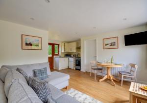 a living room with a couch and a table at Acorn Cottage in Briston