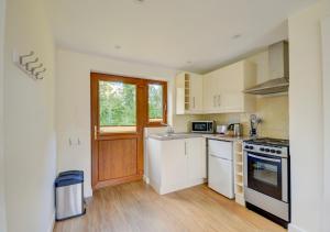 a kitchen with white appliances and a window at Acorn Cottage in Briston