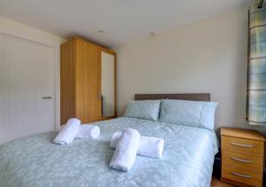 a bedroom with a bed with two pillows on it at Acorn Cottage in Briston