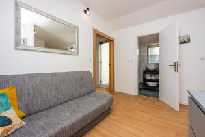 a living room with a couch and a mirror at Apartments Kala in Crikvenica