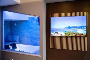 a bathroom with a tv hanging on the wall at Riverbed in Sarno