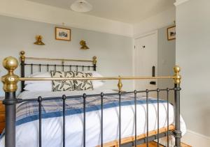 a bedroom with a bed with a metal frame at Albert Cottage in Holt