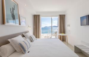 a bedroom with a bed and a view of the ocean at Ferrer Concord Hotel & Spa in Can Picafort