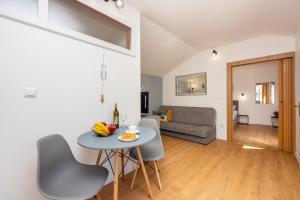 Il comprend une cuisine et un salon avec une table et des chaises. dans l'établissement Apartments Kala, à Crikvenica