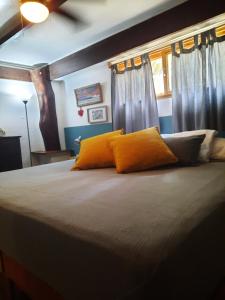 1 dormitorio con 1 cama grande con almohadas de color naranja en Casa SILURI, en Santa Teresa Beach