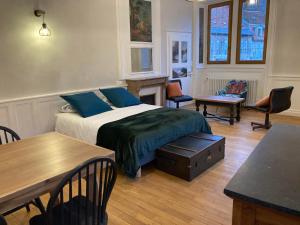 1 dormitorio con 1 cama, mesa y sillas en Maison La Tourelle, en Baume-les-Dames