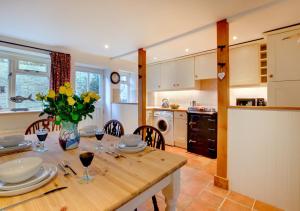 cocina y comedor con mesa de madera en Angel Cottage, en Burnham Market