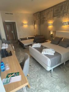 a bedroom with a bed and a couch and a table at Hotel Madeira Centro in Benidorm
