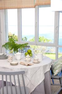 einen Esstisch mit einem weißen Tischtuch in der Unterkunft Wishome-Casa muy grande con precioso jardín en Comillas in Comillas + 20 Fotos