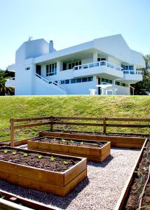 une maison avec une clôture et 2 lits surélevés devant une maison dans l'établissement Impresionante villa sobre el mar en el mismo Comillas, à Comillas