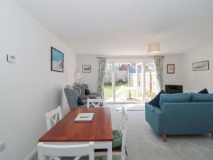 a living room with a blue couch and a table at Covert Cottage in Axminster