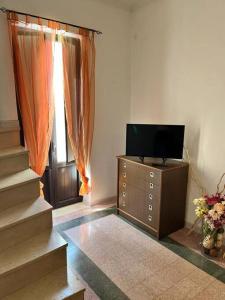 una sala de estar con TV en un tocador y una ventana en Appartamento Domarì, en Turi