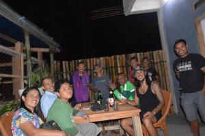 a group of people sitting around a table at Mahoni Guest House Labuan Bajo in Labuan Bajo