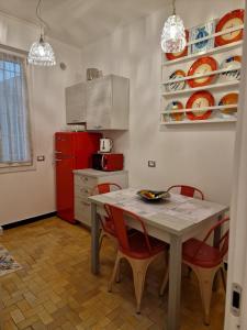una cucina con tavolo, sedie e frigorifero rosso di Una finestra sul mare accanto alle 5 Terre a Levanto