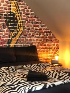 a bedroom with a brick wall and a zebra bed at Le studio d'Angèle : Blondie in Bruz