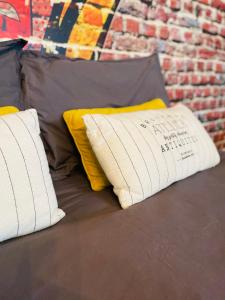 two pillows on a bed with a brick wall at Le studio d'Angèle : Blondie in Bruz