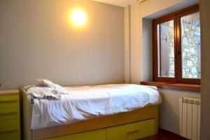 a small bedroom with a bed and a window at Apartament rústic amb llar de foc by RURAL D'ÀNEU in Valencia de Aneu