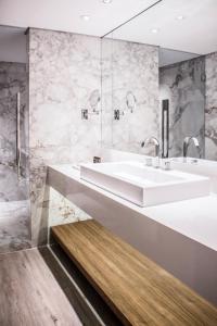 uma casa de banho com 2 lavatórios e um chuveiro em Nomaa Hotel em Curitiba