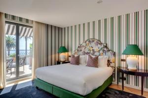 um quarto com uma cama grande e uma varanda em Portie Deluxe Suites by DA'HOME no Porto