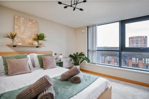 a bedroom with a bed and a large window at Leeds Most Stunning Penthouse! - Sleeps 8 in Leeds