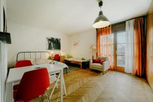 a living room with a bed and a table and red chairs at Pi House in Ljubljana