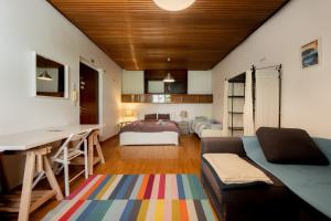 a living room with a couch and a bed at Pi House in Ljubljana