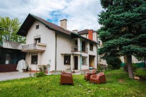 an old house with chairs in the yard at Pi House in Ljubljana