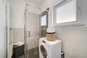 a washing machine in a bathroom with a shower at Haus Tanja Apartment 1 in Parcines +8 photos