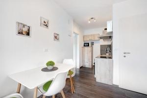 eine Küche und ein Esszimmer mit einem weißen Tisch und Stühlen in der Unterkunft Haus Tanja Apartment 1 in Partschins