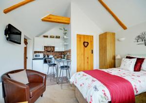 a bedroom with a bed and a kitchen at Badger Set in Cantley