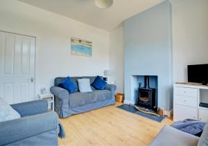 a living room with a couch and a fire place at Beachcomber Cottage in Hunstanton