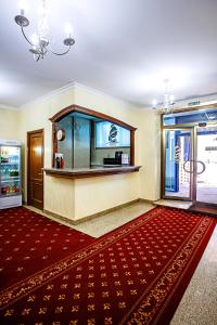 a lobby with a large red rug and a counter at KORSAR in Astana