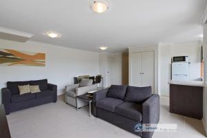 ein Wohnzimmer mit 2 Stühlen, einem Sofa und einem Tisch in der Unterkunft 2-146 Thompson Ave Cowes in Cowes