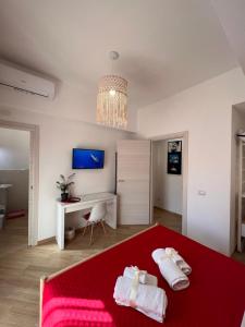 1 dormitorio con cama roja y escritorio en Casa Dharma en Civitavecchia