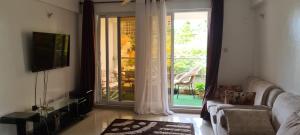 a living room with a couch and a sliding glass door at Lux Suites 3 Bedroom Hydro Apartments Nyali in Mombasa