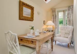a dining room with a wooden table and chairs at Baytree Cottage in Melton Constable