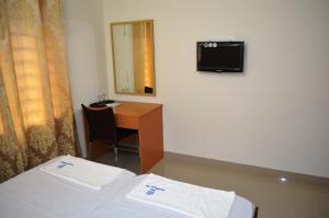 Pokój z łóżkiem, biurkiem i lustrem w obiekcie Hotel Prathiba Heritage w mieście Thiruvananthapuram