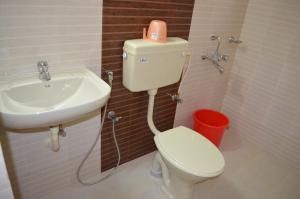 ein Badezimmer mit einer weißen Toilette und einem Waschbecken in der Unterkunft Hotel Prathiba Heritage in Thiruvananthapuram