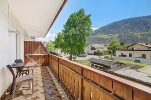 a balcony with a wooden fence and a table and chairs at Haus Tanja Apartment 2 in Parcines