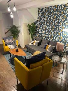 a living room with couches and chairs and a wall at B&B ArdennesT in Bouillon