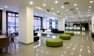 a lobby with couches and chairs in a building at NH La Avanzada in Leioa