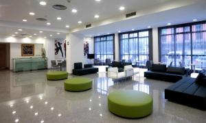 a large lobby with couches and chairs and windows at NH La Avanzada in Leioa