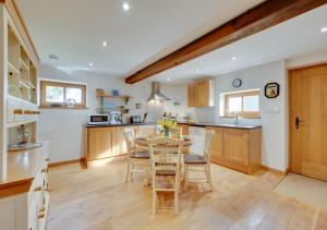 uma cozinha com uma mesa e cadeiras numa cozinha em Bluddles Dairy em Somerton