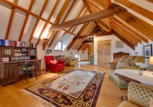 uma ampla sala de estar com tectos em madeira e um grande tapete em Bluddles Dairy em Somerton