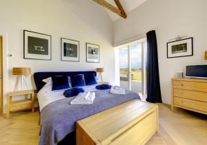 a bedroom with a bed with blue pillows and a window at Blue Tile Farm Barn in Saxlingham