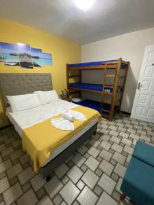 Un dormitorio con una cama con sábanas amarillas y una escalera en Pousada do Luar Cabo Frio, en Cabo Frío
